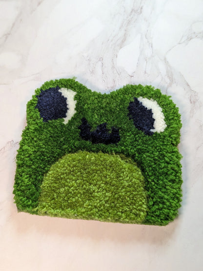 tufted frog mug rug on a marble surface