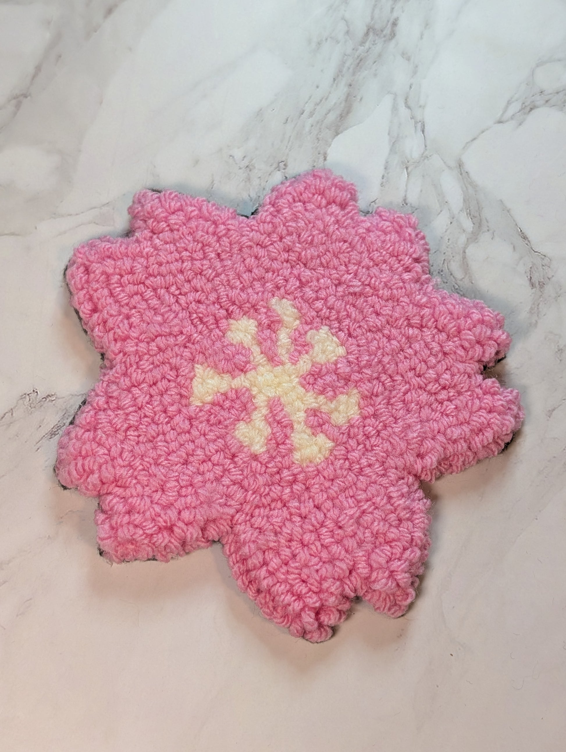 punch needle sakura mug rug on marble surface
